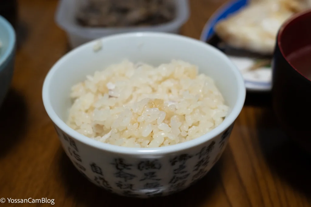 夜の食卓で撮影したごはん。シャッタースピード1/100秒で米粒の輪郭がはっきり写っている